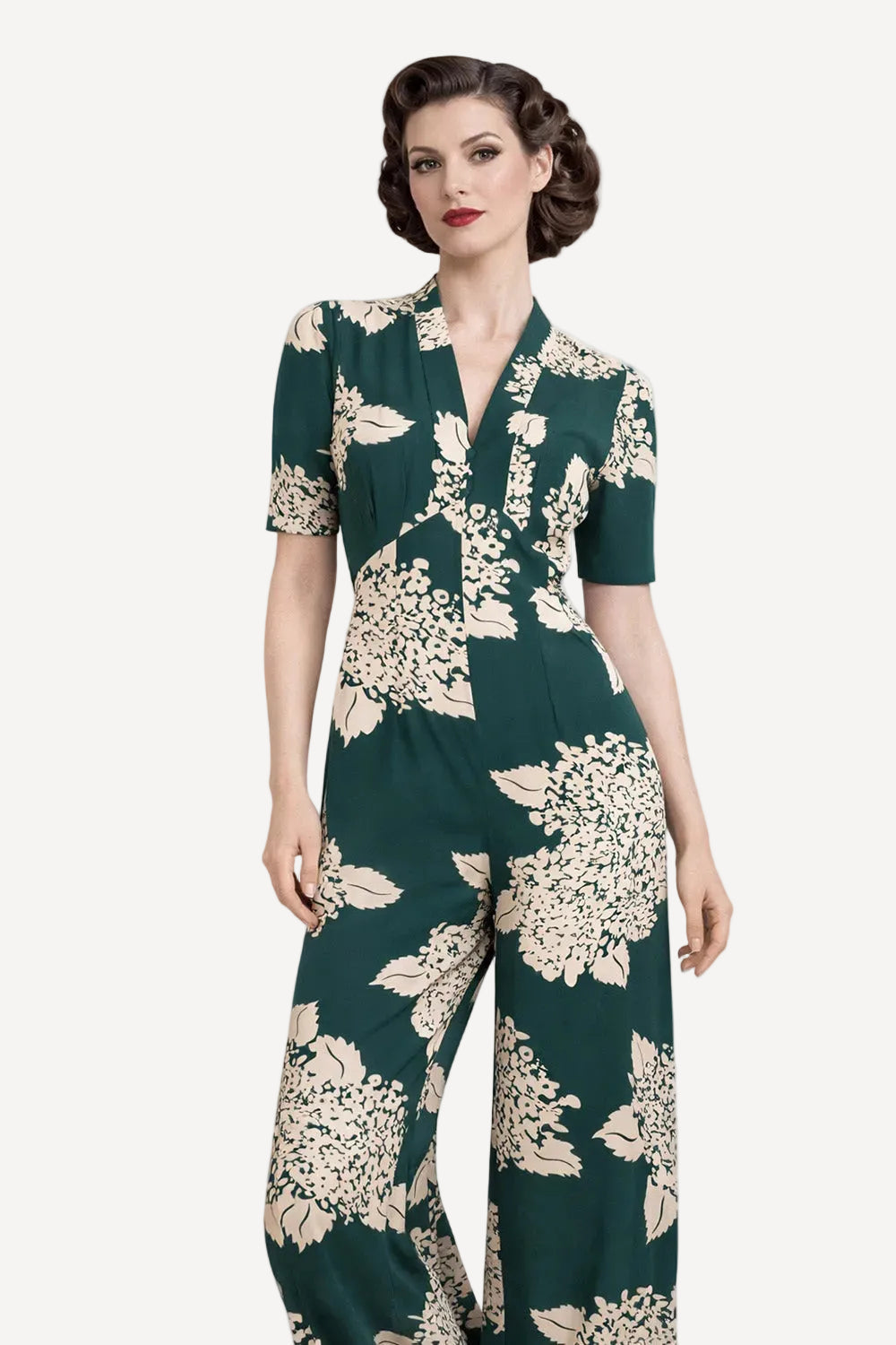 Woman wearing a green floral jumpsuit on a white background