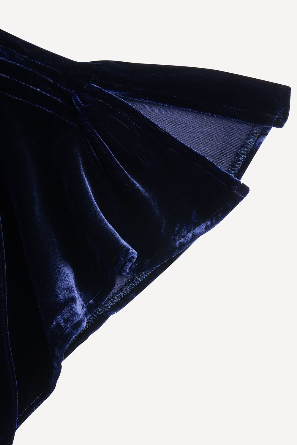 Close-up of dark blue velvet fabric on a white background