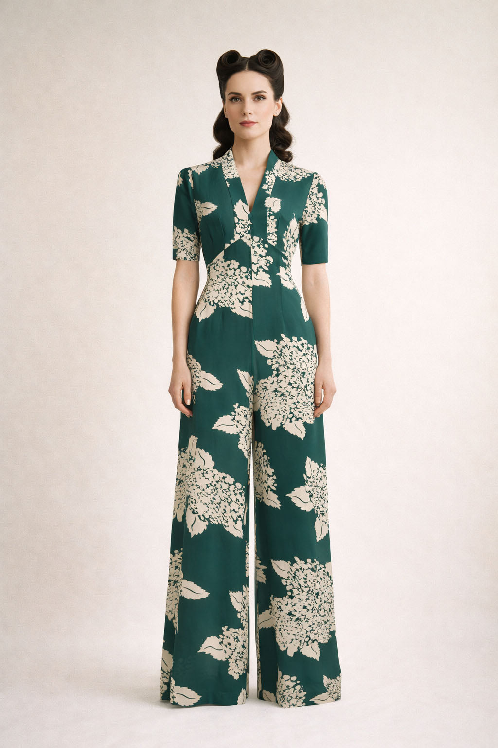Woman wearing a green floral jumpsuit on a white background